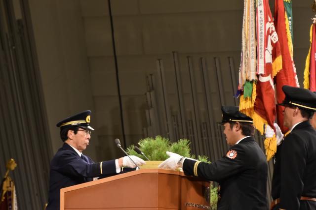 西脇隆俊京都府知事から表彰状を受領する桂健二河原林分団長の画像