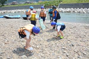 川岸のごみを拾う子どもたち