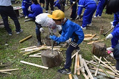 竹を縦に割る児童の画像