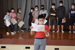 台本を参考に演じる児童の画像