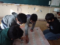 手作り都道府県の双六に興じる児童の画像