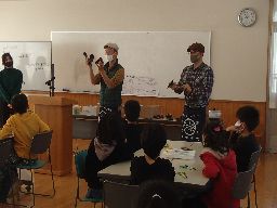 京都市芸術大学の先生が子どもたちに漆の説明をしている様子