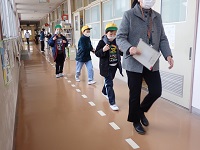 廊下を非難する児童の画像