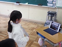 質問をタブレットに投げかける児童の画像