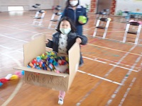色紙のリングチェーンを運ぶ児童の画像