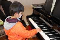 合奏でピアノを弾く児童の画像