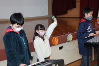 電子ピアノと鈴担当の児童の画像
