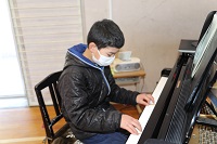 PTA合唱を児童がピアノ伴奏を担当する画像