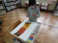 クレパスや水彩画を使って絵を描く児童の画像