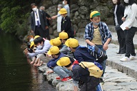 五十鈴川をのぞき込む児童らの画像