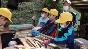 竹材を窯に詰める児童の画像