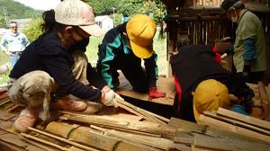 更に上から竹材を詰める作業をする児童の画像