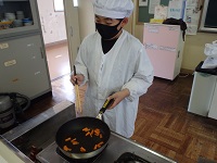 フライパンの野菜を炒める児童の画像