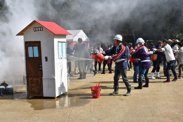 実践訓練で町民の皆さまと畑野町自主防災会の人たちが連携して行ったバケツリレーのようすの画像