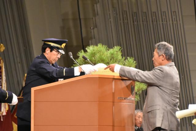 西脇隆俊京都府知事から表彰状を受領される西村満西別院町自主防災会長の画像