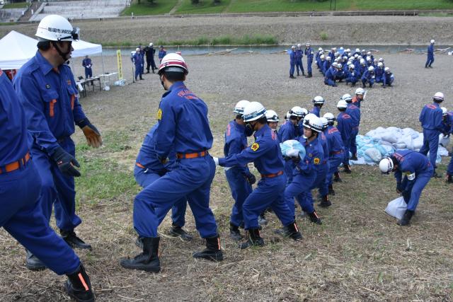 作製した土のうをリレー形式で運ぶようすの画像