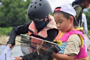 網を使って生き物をとる子ども