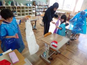 ビニール袋を加工する女子児童らの画像