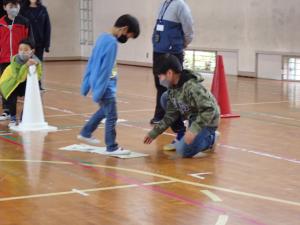 新聞を移動させその上を移動する児童の画像