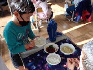 ご飯の分量を調整する児童の画像