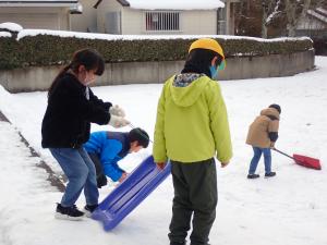 順番よくそりを交代で乗る児童らの画像