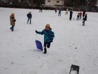 雪の腹を駆ける児童らの画像