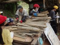 竹材を運ぶ手渡す詰めるの流れ作業の画像