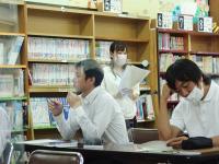 情報共有の為報告する先生の画像