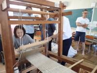 織り手をのぞき込む職員の画像