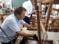 ベテラン職員も織り機を体験する画像