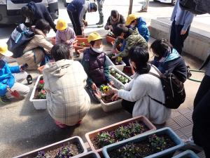 親子で花を植える作業をする画像