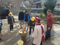 餅つき体験をする5年生男児の画像