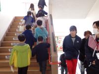 校舎内階段を階上へ移動する児童らの画像