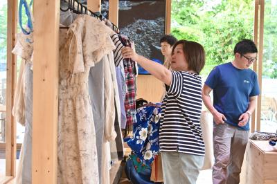 展示された服を手に取る人